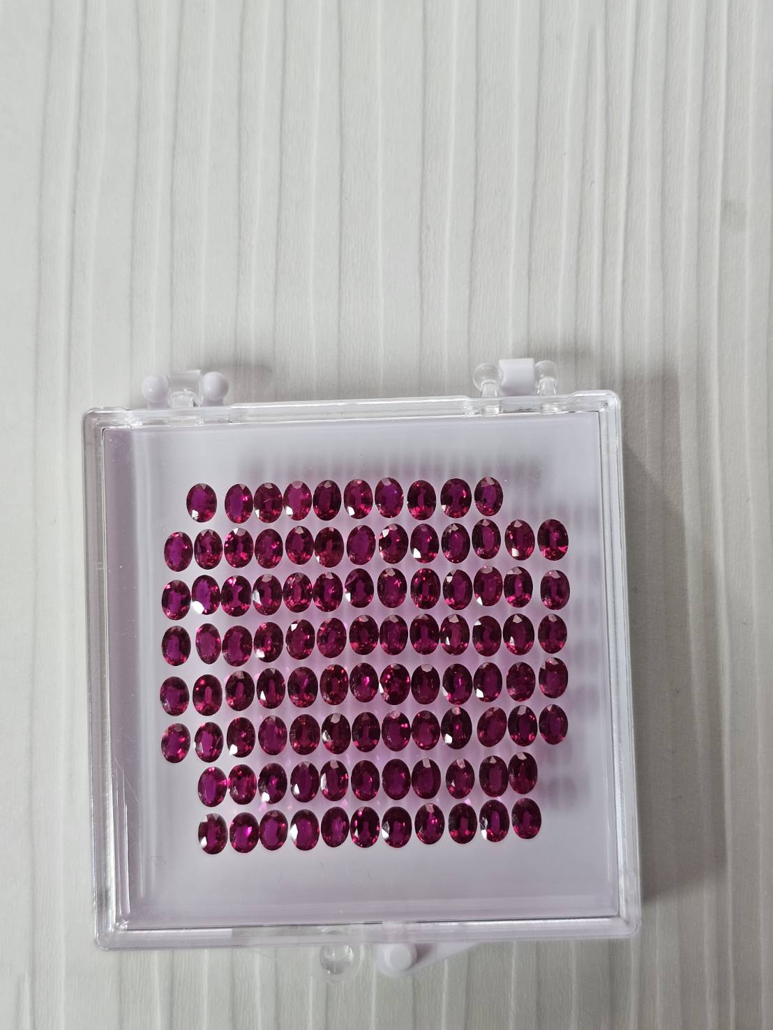 Parcel of oval ruby stones arranged in a gem tray